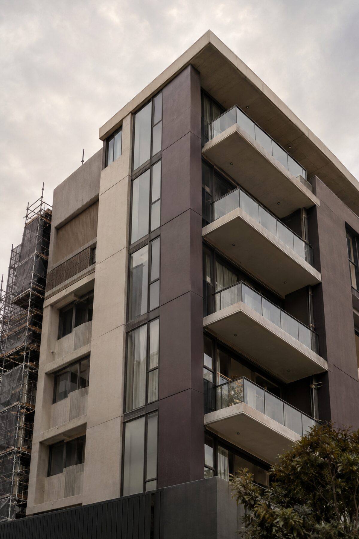 Modern multi-residential concrete and glass facade in Brisbane with scaffolding to one side